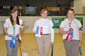 4-Hers and their dogs with their ribbons at a 4-H Dog show.