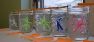 Ball jars holding snowflake shapes in water and borax mixture.