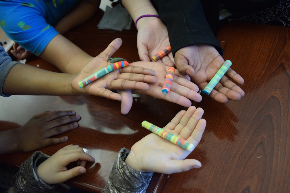 Youth holding Playdoh "core samples" after a science activity