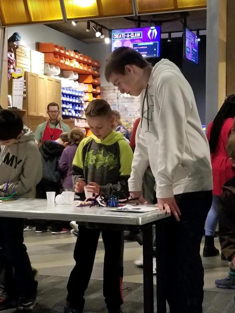 teenager and a 4-H youth at an engineering table at museum