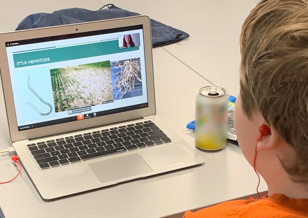 young teen boy watching a virtual science cafe session
