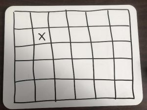 a hand drawn grid on paper with an "x" in one of the squares