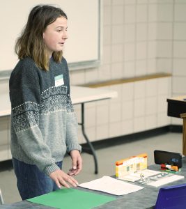 teenage presenter displaying a set of lego toys, 4-H Public Speaking event, 2022