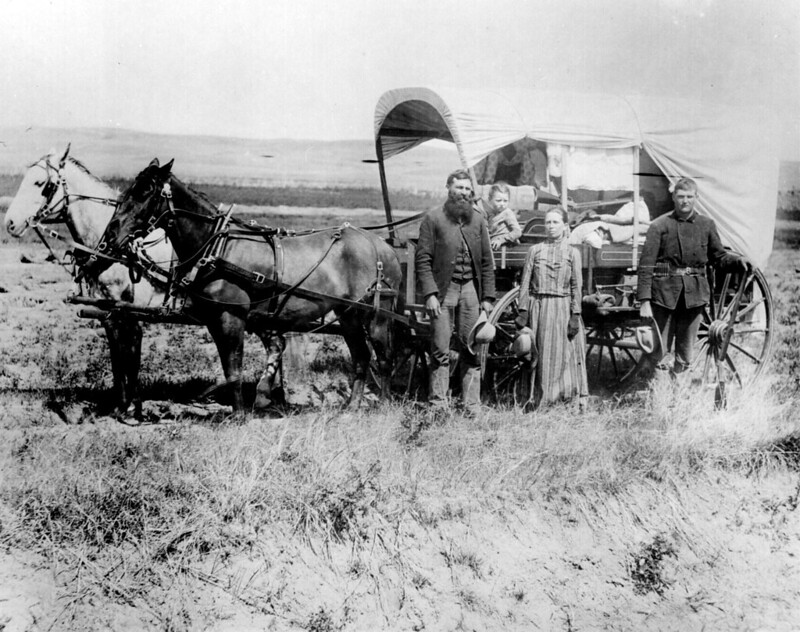 The Covered Wagon of the Great Western Migration. 1886 in Loup Valley, Nebr. A family poses with the wagon in which they live and travel daily during their pursuit of a homestead.