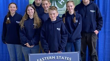 2024 Maine 4-H ESE Sheep Team posing together with a 4-H flag.