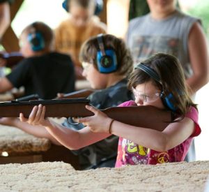 a young 4-H member at a shooting range