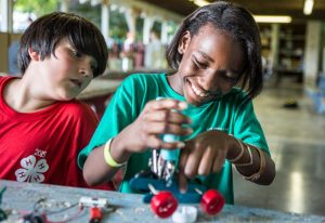 two pre-teen 4-H members working on a robotics project