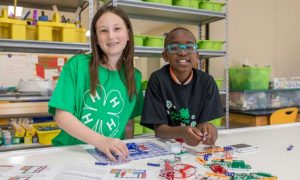 two young participants working, putting together a 4-H project