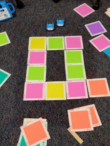 Different colored cards are used to control robotic cars.