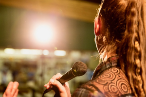 a teenager singing into a microphone on a stage