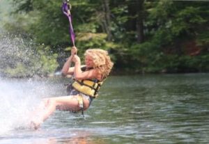 teenager swinging on a rope into a lake