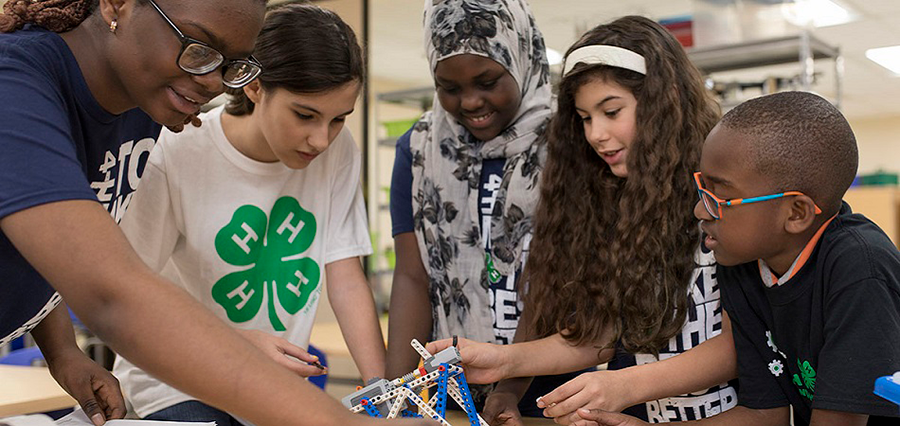 a group of mentors and 4-H youth working on a STEM project