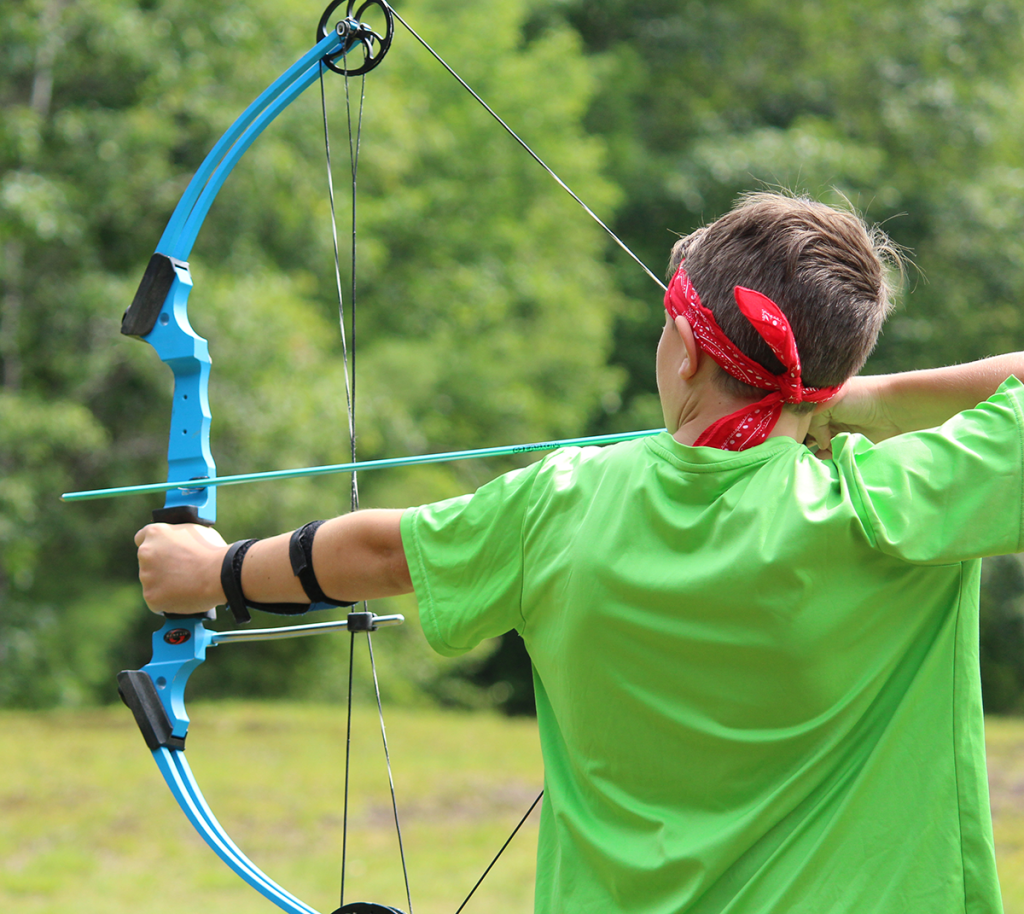 a 4-H camper pulling an arrow on a bow while participating in an archery activity