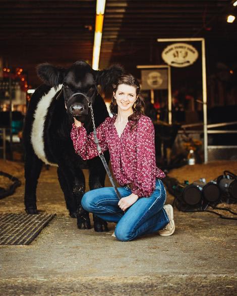 Sadie Olmstead pictured with a cow in a barn