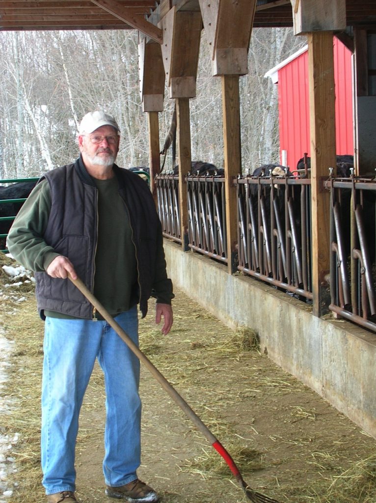 farmer with tool in hand in cattle barn