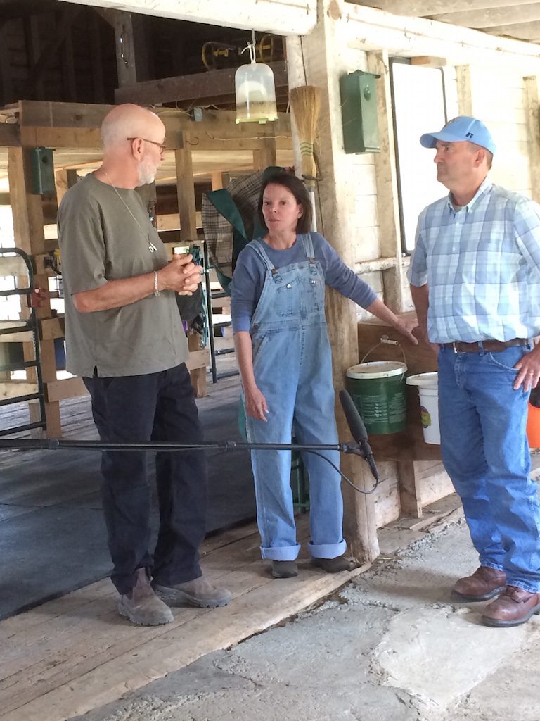 3 people talking in a barn