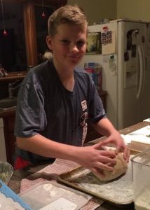 child kneading dough
