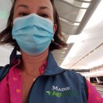woman with mask and AgrAbility logo vest