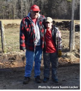 Man and boy standing in farmyard