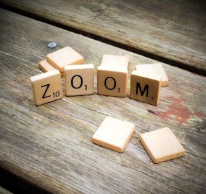 Scrabble game letters spelling the word "ZOOM"