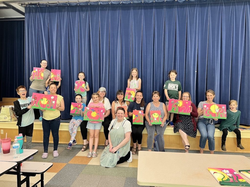 4-H members and mothers posing with their paintings
