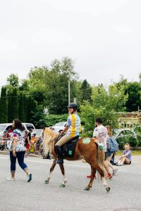 A 4-H member riding a horse in a parade