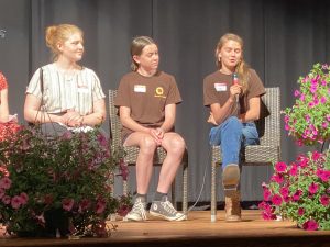 Two 4-H members speaking on a stage