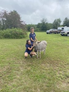 Two 4-H members petting a goat