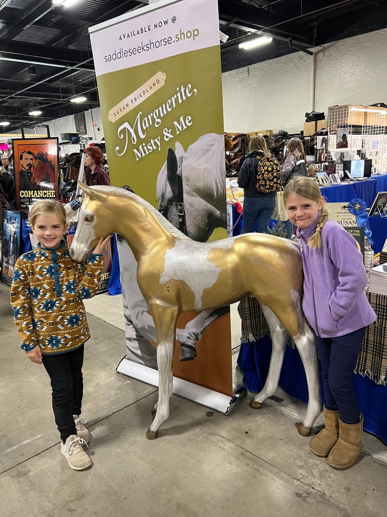 Two Midcoast Mainers members posing with a plastic golden horse