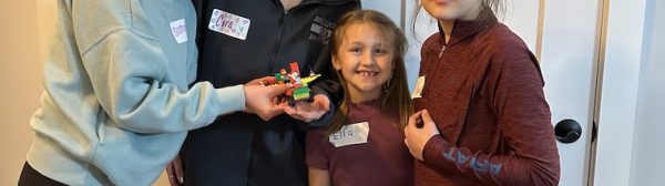 Clara, Summit, and two Cloverbuds posing with a lego vehicle