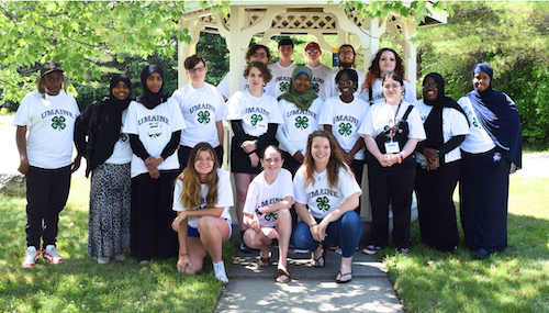 Summer of Science teen leaders wearing "UMaine 4-H" tee shirts posing for a photo.