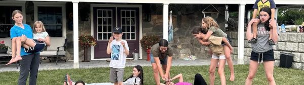 Midcoast Mainers posing on a lawn in front of a house.