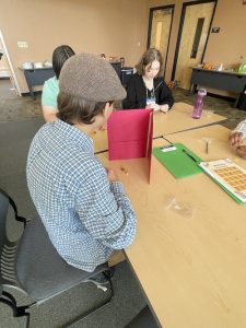 Three teen leaders doing an activity at a table.