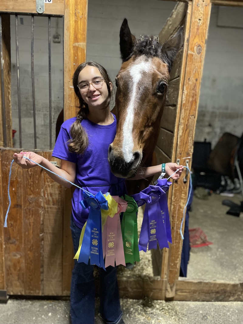 A Midcoast Mainer posing with a horse and 7 award ribbons.