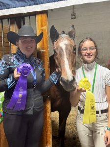 Two Midcoast Mainers posing with a horse and their award ribbons.