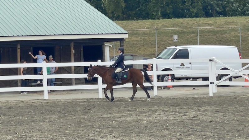 A Midcoast Mainer riding a horse in a competition area.