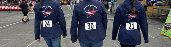 3 Midcoast Mainers walking through the Big E, wearing matching jackets.