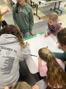 Children writing on a poster.