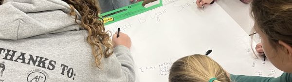 Children writing on a poster.