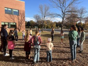 Children standing in a circle outdoors.