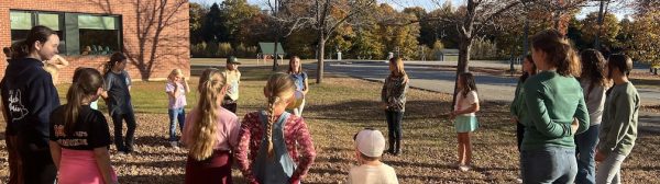 Children standing in a circle outdoors.