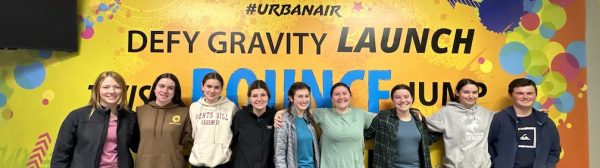 Group photo of GLEE members in front of an Urban Air sign.