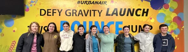 Group photo of GLEE members in front of an Urban Air sign.