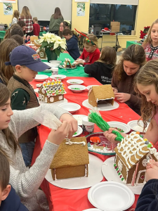 Midcoast Mainers sitting at a table and building gingerbread houses