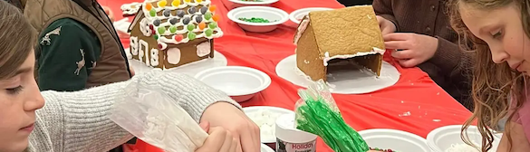 Midcoast Mainers sitting at a table and building gingerbread houses