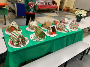 Gingerbread houses made by Midcoast Mainers lined up on a table.