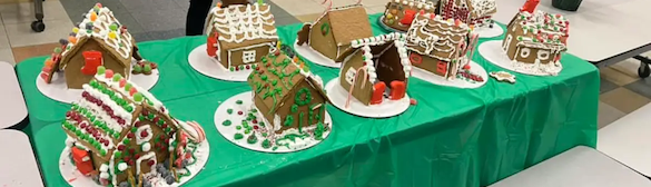 Gingerbread houses made by Midcoast Mainers lined up on a table.