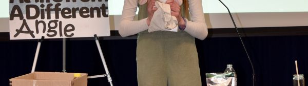 A child presenting on "Looking at life from a different angle", while holding a toy rabbit.