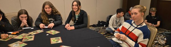 A group of teenagers sitting around a table.