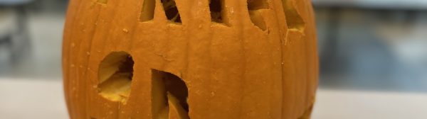 Pumpkin with "trick or treat" carved into it.